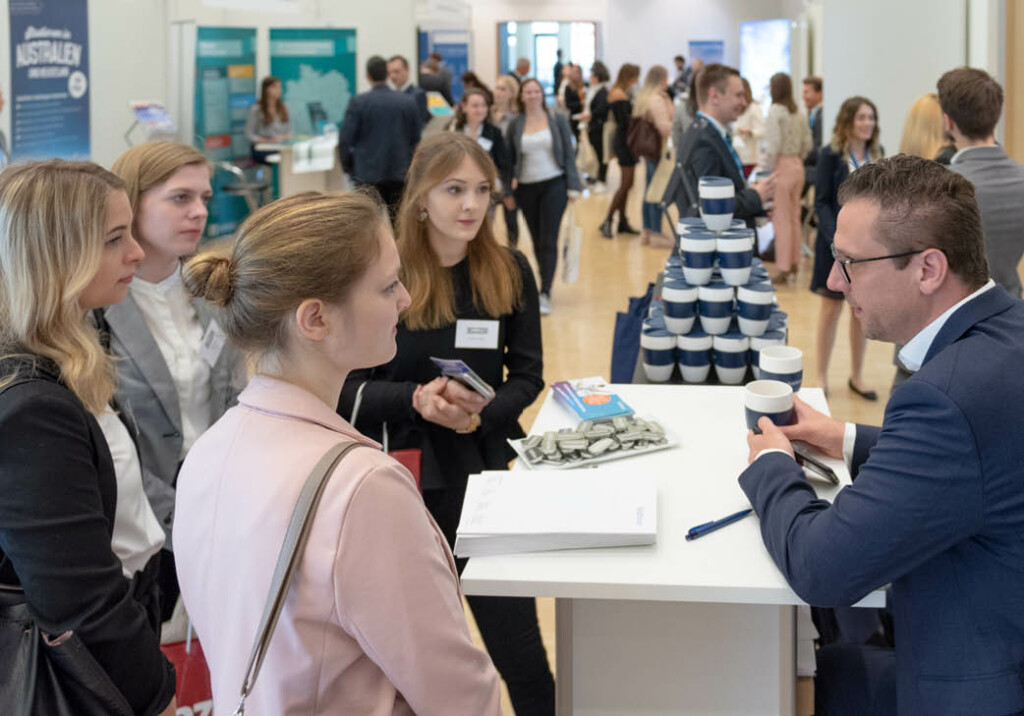 Karrieremesse - Gruppe von Bewerbern und Ausstellern im Gespräch