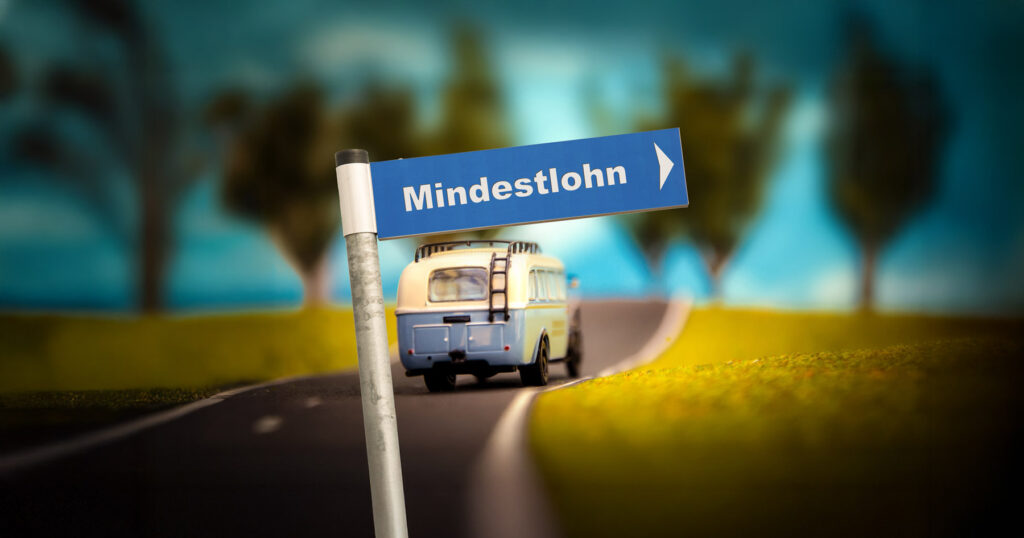 Mindestlohn, juristische Eischätzung. Symbolbild mit Wegweiser